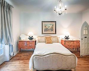 a bedroom with a bed and two dressers and a chandelier at Château de Najade in Sainte-Sévère-sur-Indre