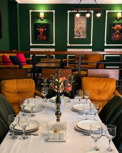 a table with plates and wine glasses in a restaurant at Arazani in Lagodekhi