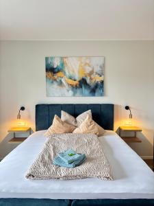 a bedroom with a white bed with two lamps at Apartment mit Parkblick in Bad Rothenfelde