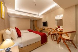 a hotel room with a bed and a table and a desk at Hotel Grand Courtyard Pala in Pala