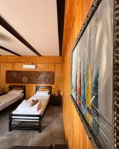a room with two beds and a painting on the wall at Arazani in Lagodekhi
