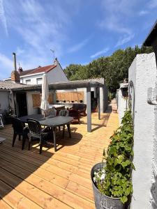 a wooden deck with a table and chairs on it at La maison de mamy in Bray-Dunes