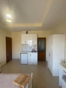 a kitchen with white cabinets and a counter top at Honey Residence in Sarandë
