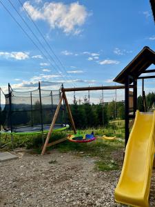 a playground with two slides and a swing set at Tatra Widok in Bukowina Tatrzańska