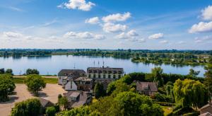 an aerial view of a building on a lake at Hotel Hoogeerd by Flow Niftrik - Nijmegen in Niftrik +16 photos