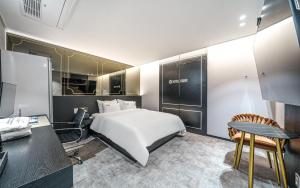 a bedroom with a bed and a desk and a table at 호텔 어게인 in Cheongju