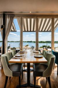 a dining room with a table and chairs and a large window at Hotel Hoogeerd by Flow Niftrik - Nijmegen in Niftrik