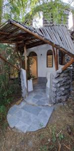 a small house with a stone building with a roof at Nchaman Nest in Loiyangalani 