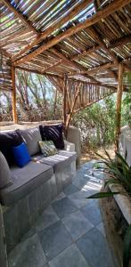 a couch sitting under a wooden pergola at Nchaman Nest in Loiyangalani 