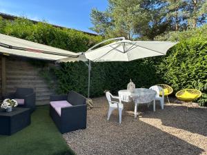 a patio with a table and chairs and an umbrella at Aux Lofts de VERDUN in Verdun-sur-Meuse