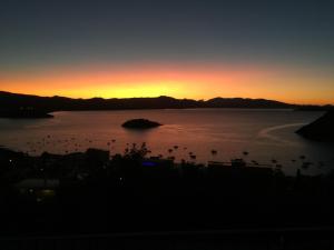 a sunset over a body of water with a group of birds at Daphne Bungalows in Tolo +45 photos