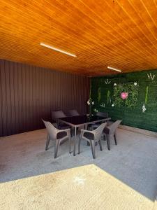 a dining room with a table and chairs and a green wall at Luca Rooms in Curtea de Argeş