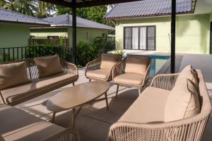 a group of wicker chairs and tables on a patio at Luxury Villa with Private Pool, Srithanu in Ko Kong Nui