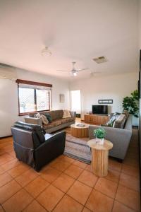 a living room with two couches and a table at Dune Break in Exmouth