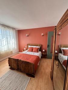 a bedroom with a large bed with red walls at La maison de mamy in Bray-Dunes