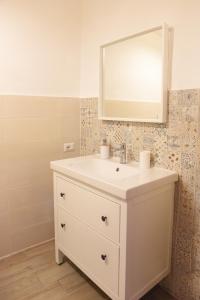 a bathroom with a white sink and a mirror at Casa Nora in Valsinni