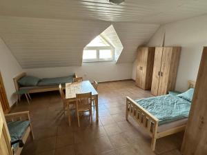 a room with two beds and a table and a dining room at Vila Stella Vita in Chrbonín