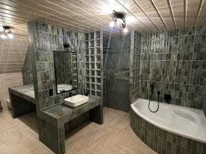 a bathroom with a tub and a sink and a bath tub at Vila Stella Vita in Chrbonín