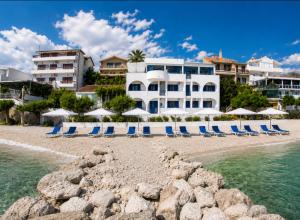 a group of chairs and umbrellas on a beach at Villa Tamaris on the beach in Podstrana