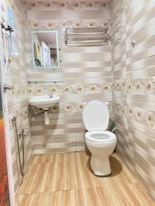 a bathroom with a toilet and a sink at Cameron Keafarm Hotel in Brinchang