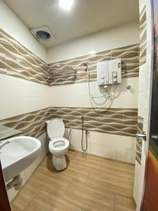a bathroom with a toilet and a sink at Cameron Keafarm Hotel in Brinchang
