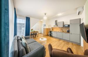 a living room with a couch and a kitchen at Citadines South Vienna in Vienna