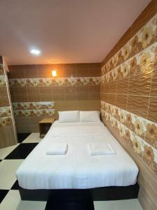 a bedroom with a bed with two towels on it at Cameron Keafarm Hotel in Brinchang
