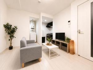 a living room with a chair and a television at Glory 豊平 -FIX HOME- in Sapporo
