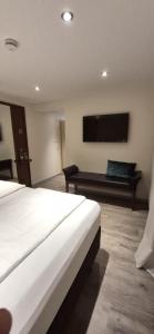 a hotel room with a bed and a flat screen tv at Berggasthof Immenstein in Bühl