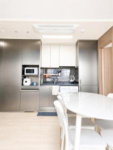 a kitchen with a white table and white chairs at Donghae Fine and You Oceancity Hotel by SND in Donghae