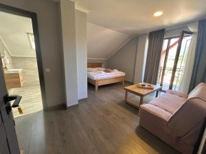 a living room with a couch and a bed at La SOFIIA in Săpânța