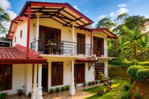 a house with a balcony in a garden at Silver Tips Villa in Ella