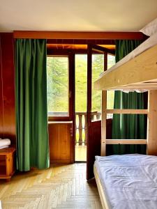a bedroom with a bunk bed with green curtains at Locanda del Lysjoch in Gressoney-la-Trinité +28 photos