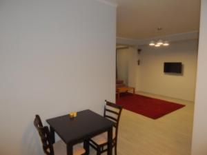 a dining room with a black table and chairs at Mircea cel Batrin apartament in Chişinău +14 photos