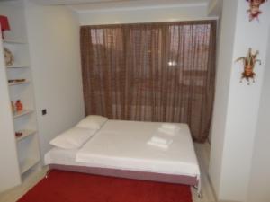a small bedroom with a white bed and a window at Mircea cel Batrin apartament in Chişinău