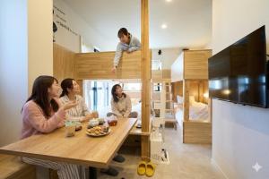 a family sitting around a wooden table in a room at Inside Sangreen - Vacation STAY 22714 in Tokyo +19 photos