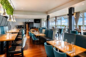 a restaurant with wooden tables and blue chairs at Hotel Hoogeerd by Flow Niftrik - Nijmegen in Niftrik
