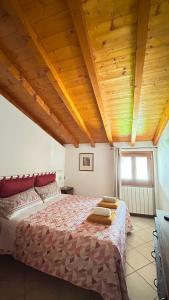 ein Schlafzimmer mit einem großen Bett und Holzdecke in der Unterkunft L'Oasi Intelvese in Pellio Superiore