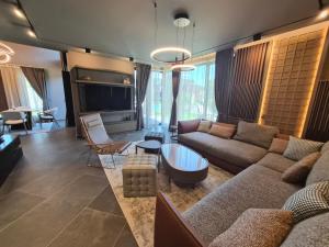 a living room with a couch and a tv at Monte SPA Villas in Banya