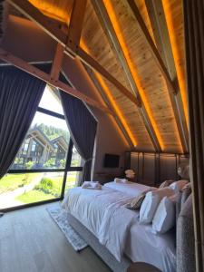 a bedroom with two beds and a large window at Monte SPA Villas in Banya +82 photos