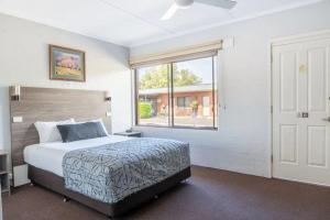 a bedroom with a large bed and a window at Nicholas Royal Motel - Hay CBD in Hay