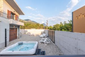 a hot tub on the patio of a house at Villa Omaha in Vekići