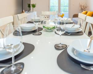 a white table with glasses and plates on it at Villa Omaha in Vekići