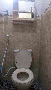 a bathroom with a toilet and a window at Ambarosed Homestay in Ngaglik