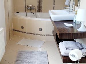 a bathroom with a bath tub and a sink at Apartament Nad Lodziarnią in Wydminy