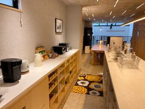a kitchen with a long counter with a counter sidx sidx sidx at 女性専用 Woman Only capsule MAJA HOTEL KYOTO マヤホテルキョウト in Kyoto