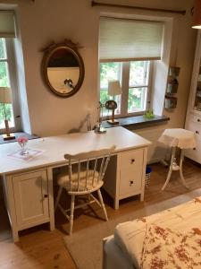 a kitchen with a desk with a chair and a mirror at Erikslund in Hurva