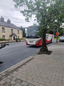a bus driving down a street next to a tree at The old B&B in Killucan