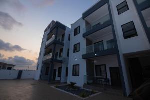 a large white building with a sunset in the background at Stay-City Oliver in Apenkwa