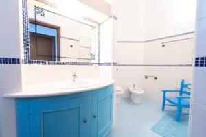 a bathroom with a blue sink and a toilet at Bidderosa in Orosei